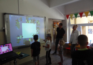 Dzieci układają puzzle przy tablicy interaktywnej